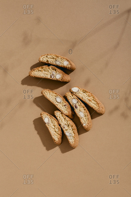 Top down view of shadow of tree branch cast over arrangement of almond biscotti