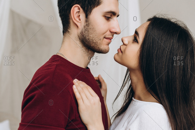 Close-up photo of a lovely young couple, guy and girl looks at each other with love