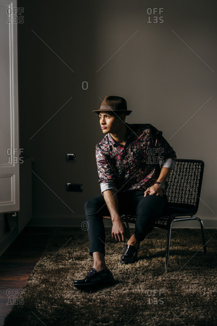 Stylish man posing on chair near son on grey Stock Photo - Alamy