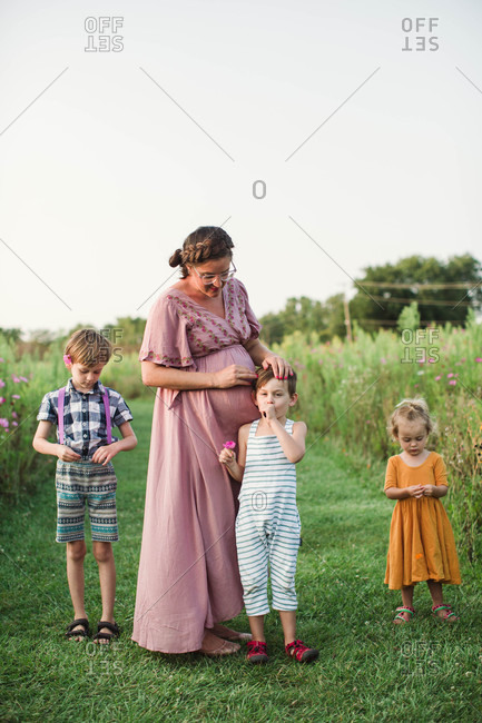 Candid outdoor portrait with pregnant mother and children