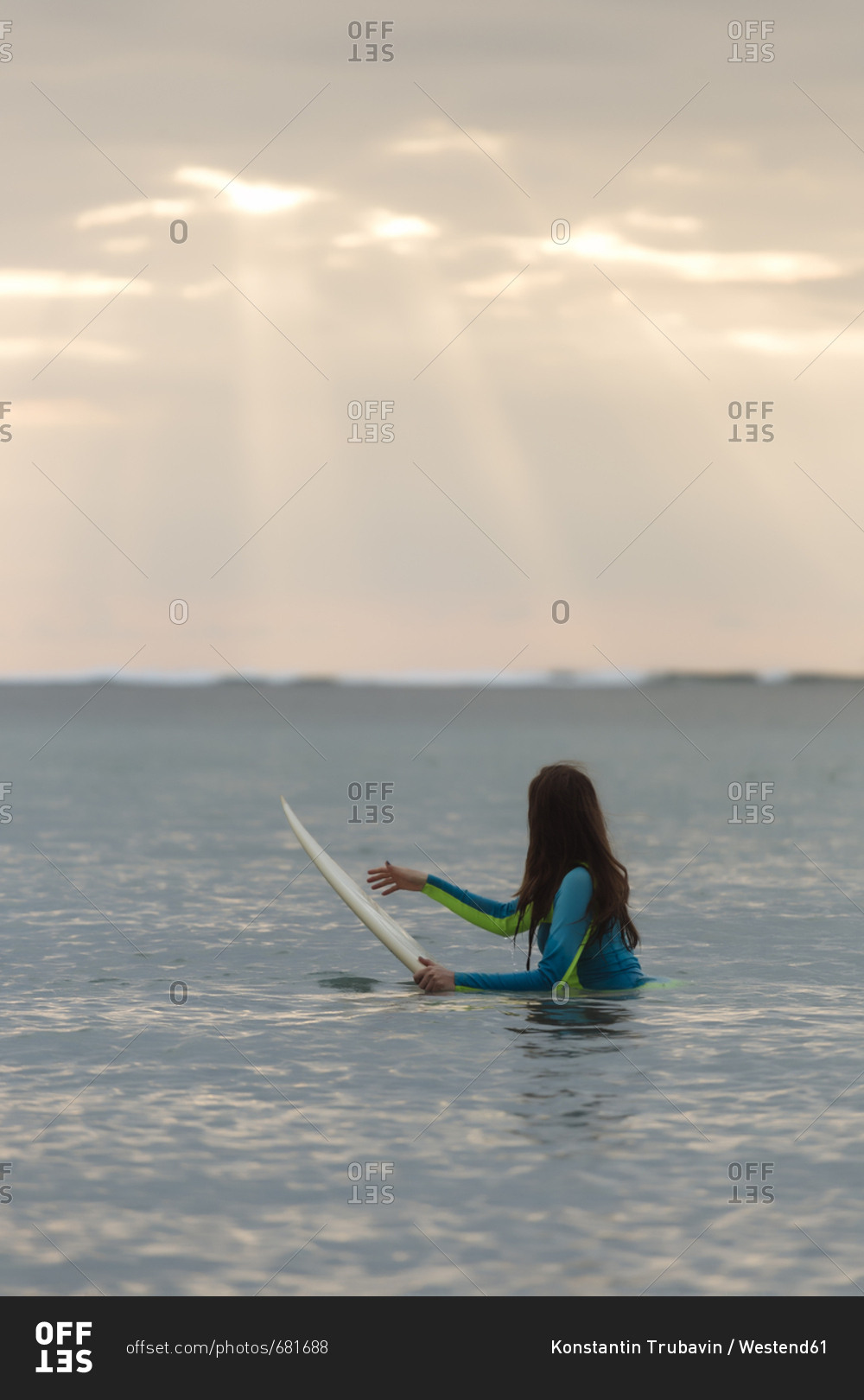 Indonesia- Bali- young woman with surf board in water
