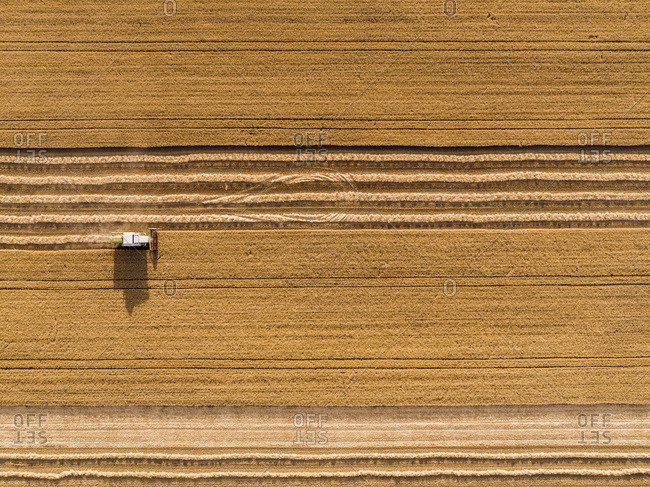 Serbia- Vojvodina. Combine harvester on a field of wheat- aerial view