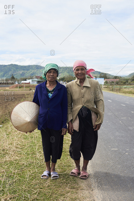Central Highlands, Vietnam - January 10, 2018: Minority ethnic vietnamese females posing at camera on the middle of the road