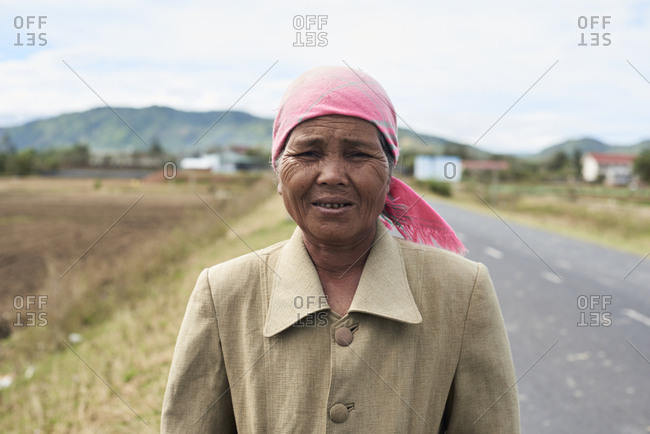 Central Highlands, Vietnam - January 10, 2018: Minority ethnic vietnamese female posing at camera on the middle of the road