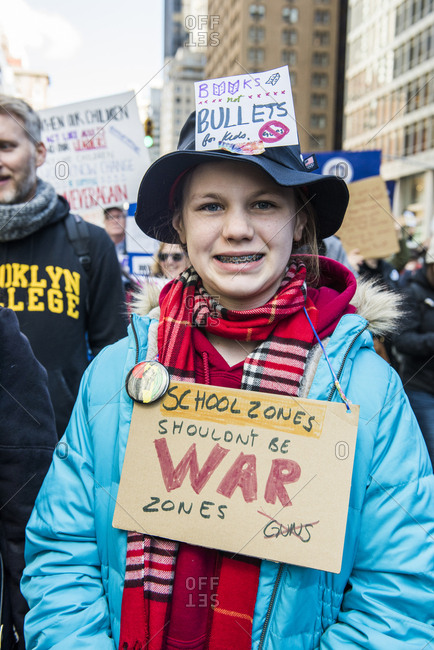 New York City, NY, USA - March 24, 2018: Young girl posing showing hand written sign around neck and on hat at March For Our Lives 2018 demonstration