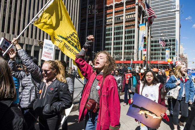 New York City, NY, USA - March 24, 2018: Young woman chanting and raising fist during March For Our Lives 2018 demonstration