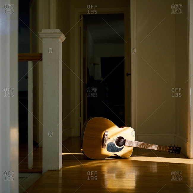 Acoustic guitar on floor in hallway