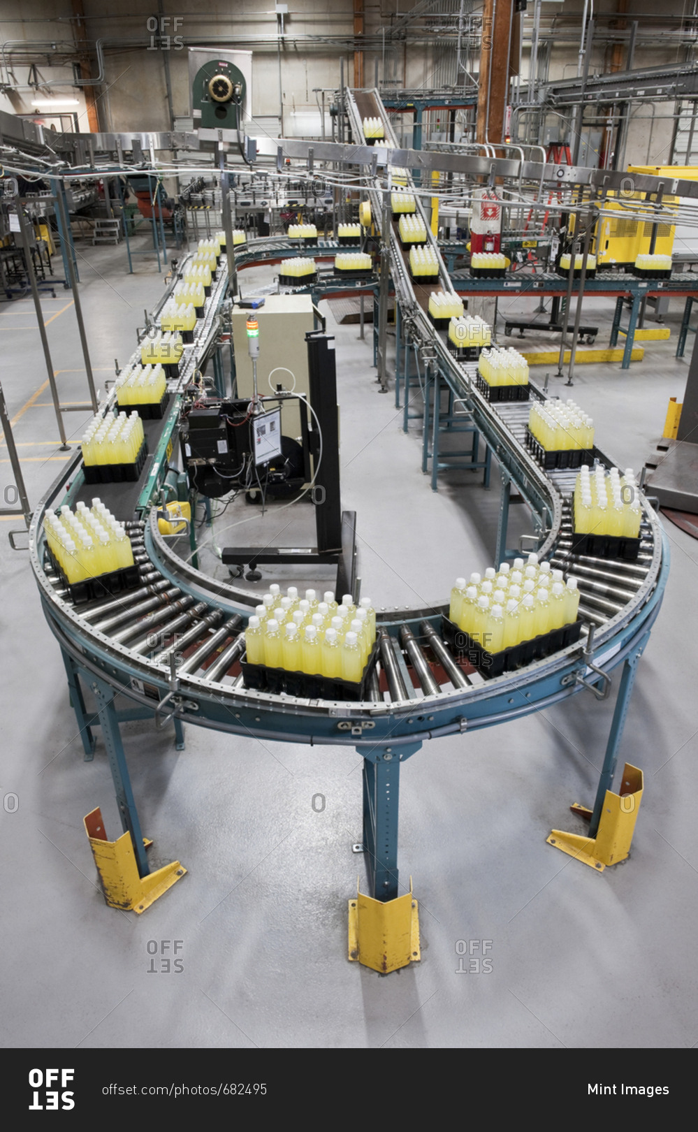 Conveyor belt full of lemon flavored bottled water in a bottling plant.