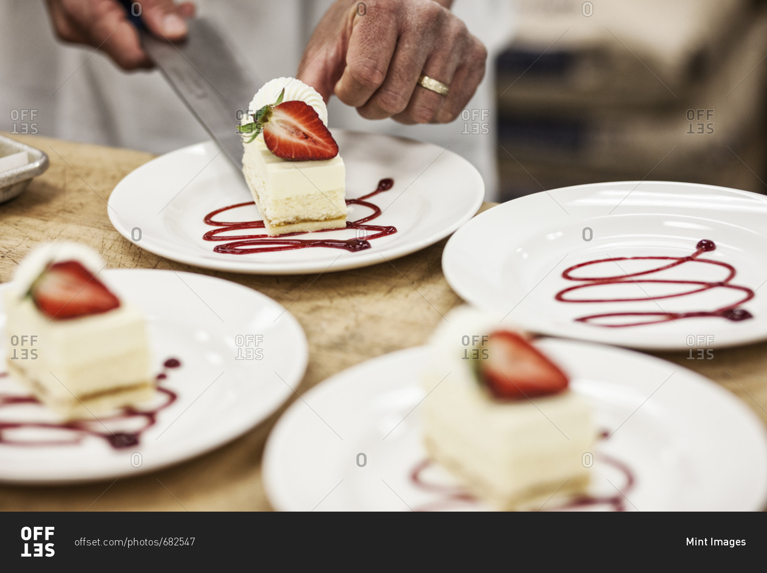 Chef hands placing a layered desert on a plate, presentation of a sweet dish.
