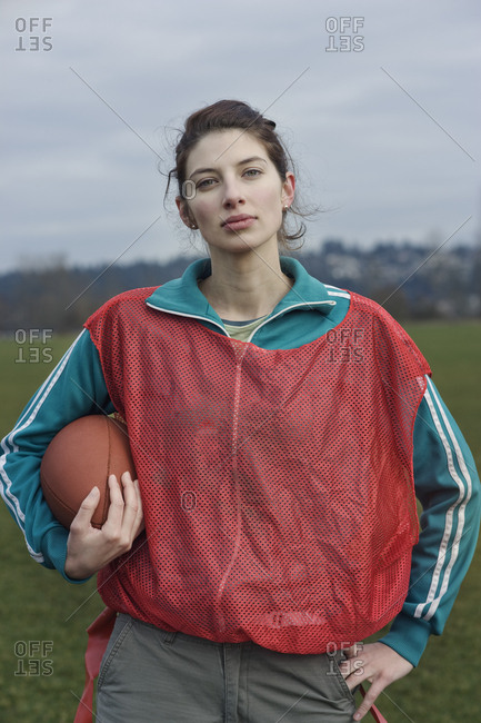 Caucasian woman member of a non-contact flag football team holding a football.
