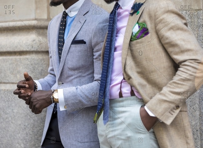 Two men wearing suits, ties and pastel shirts with contrast collar