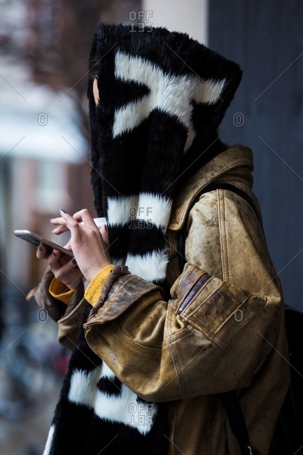 Woman with scarf over head wearing leather flight jacket