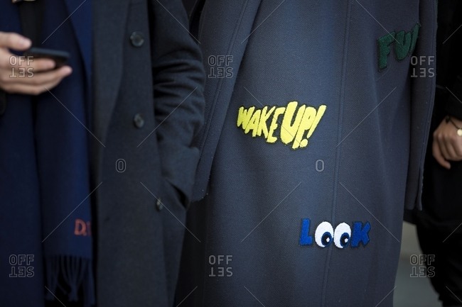 London, England - February 29, 2016: Rearview of dark winter coat with messages sewn on