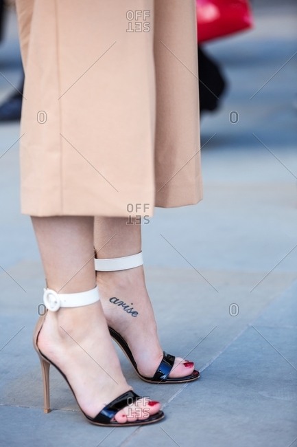 Woman in high heels with tattoo across arch of foot