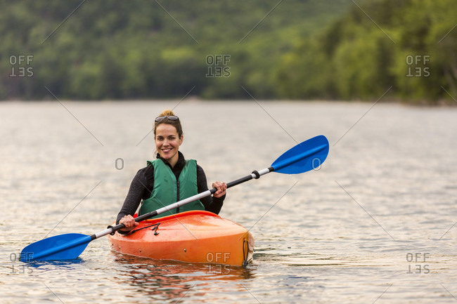 Smiling woman kayaking on Jordan Pond in Acadia National Park, Maine, USA