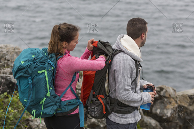Side view of couple hiking on Great Head in Acadia National Park, Maine, USA
