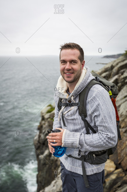 Portrait of hiker standing on cliff in Acadia National Park, Maine, USA
