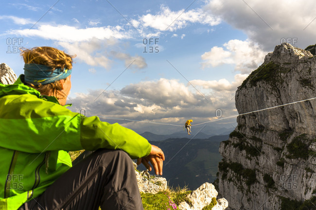 Man watching another highlining on tightrope in Lower Alps, Lower Austria, Austria