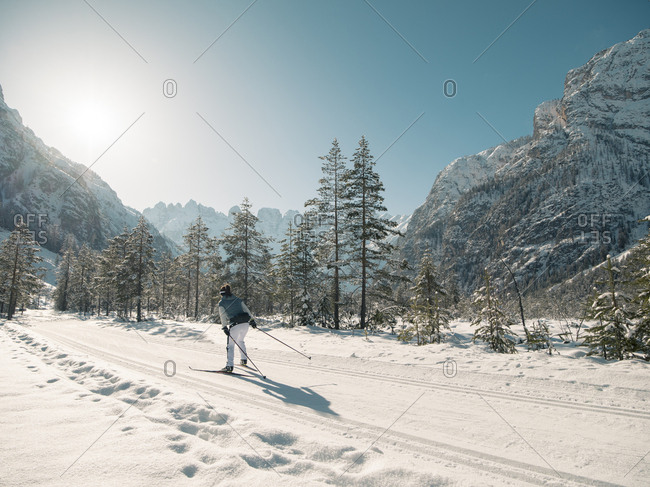 Skier practicing in front of sunny mountain skyline