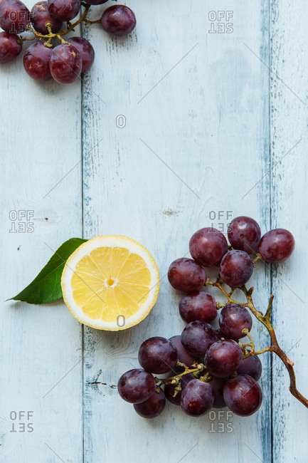 Halved lemon slice next to cluster of grapes