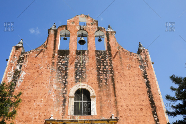 Looking up at colorful facade and bells of church in Valladolid, Mexico