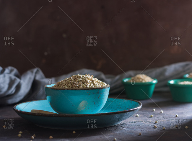 Bowl ceramic filled with buckwheat and accompanied by other cereals wheat flakes. Ideal dish for vegetarians