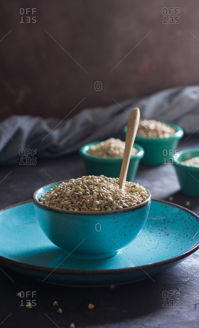 Bowl ceramic filled with buckwheat and accompanied by other cereals wheat flakes. Ideal dish for vegetarians