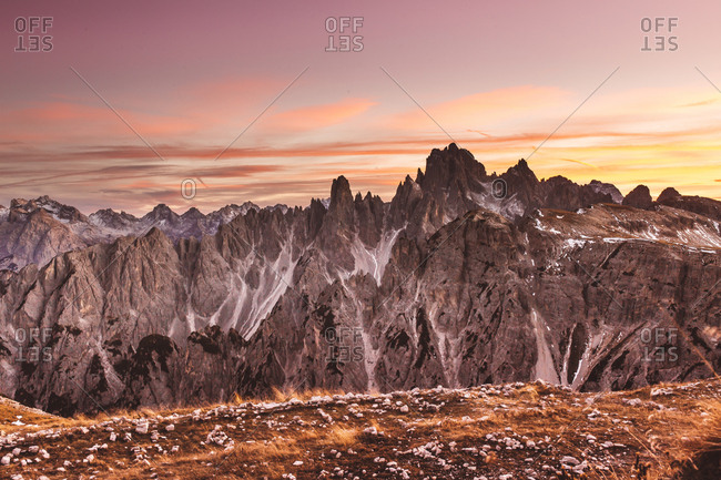 Picturesque view to beautiful peaks in sunset lights under cloudy sky.