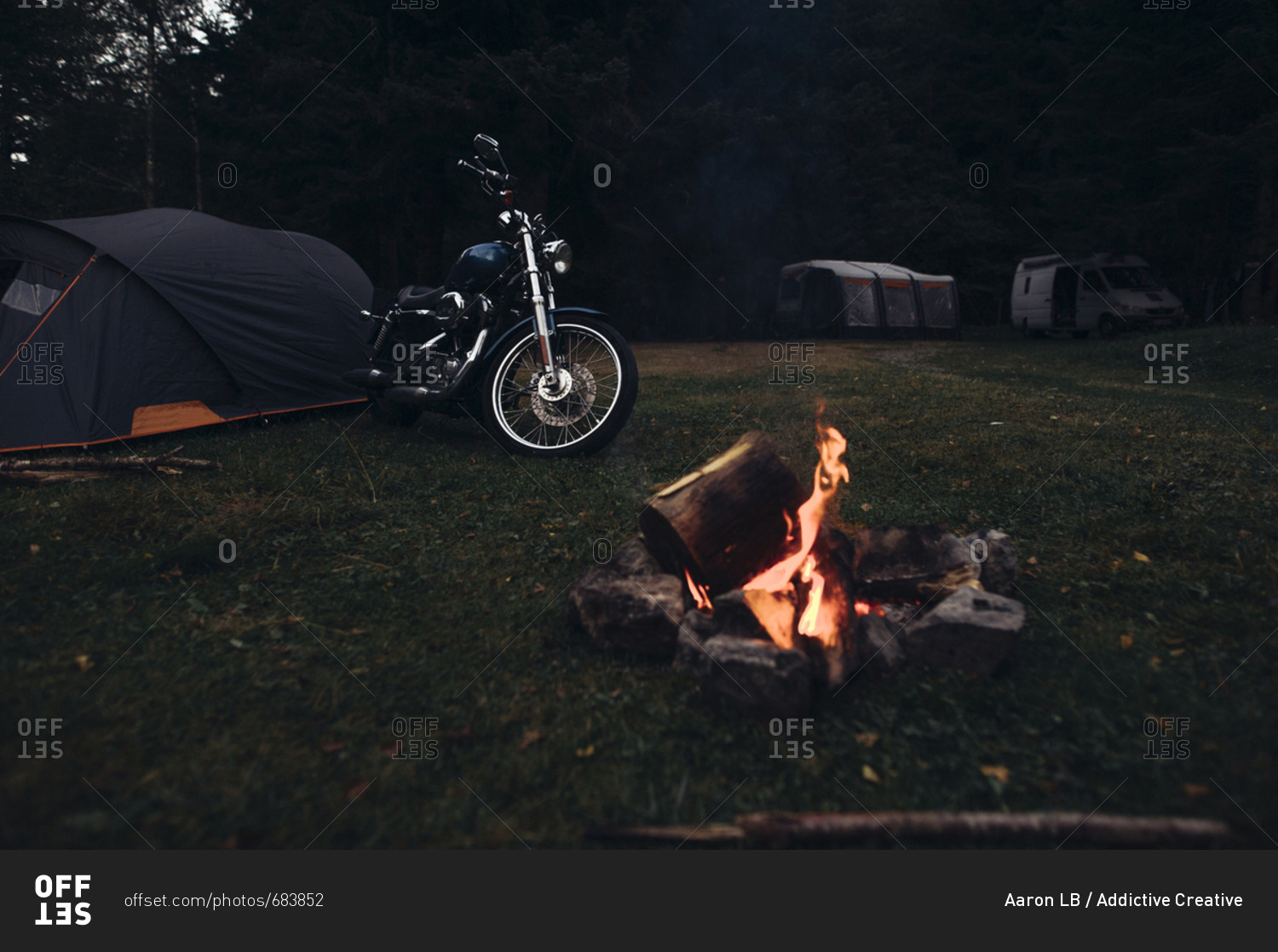 Cool motorcycle parked at campfire in nature in the evening.