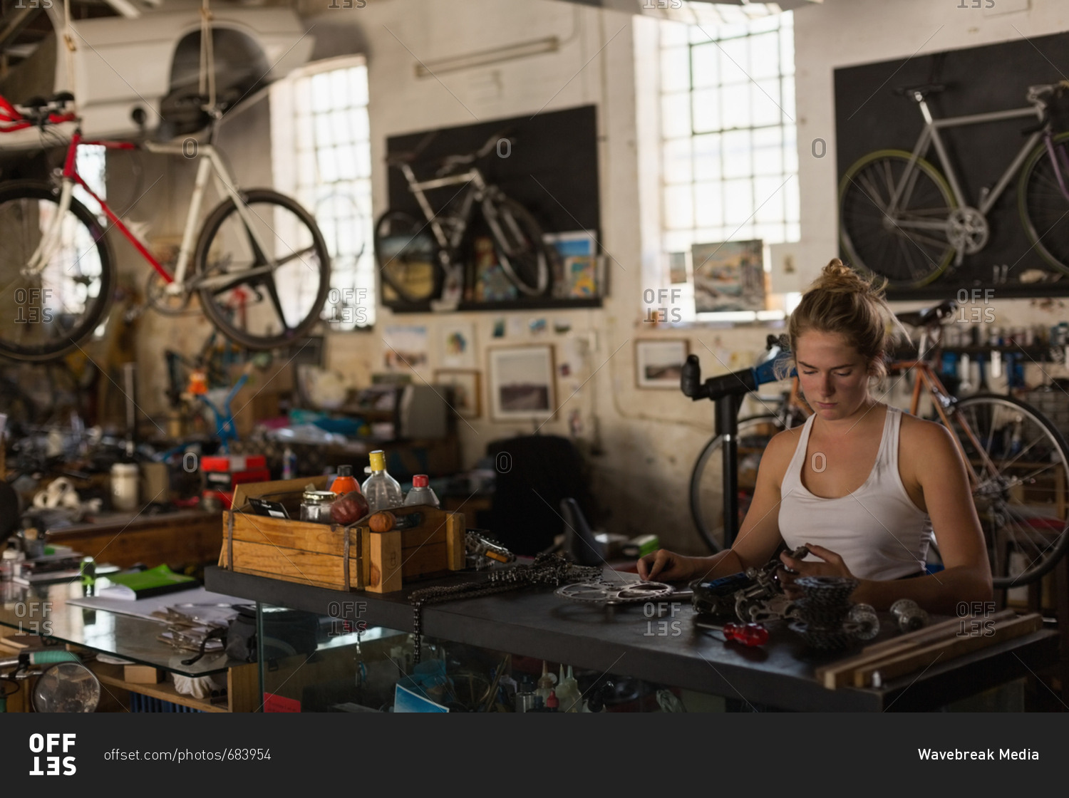 Female mechanic examining bicycle parts in workshop