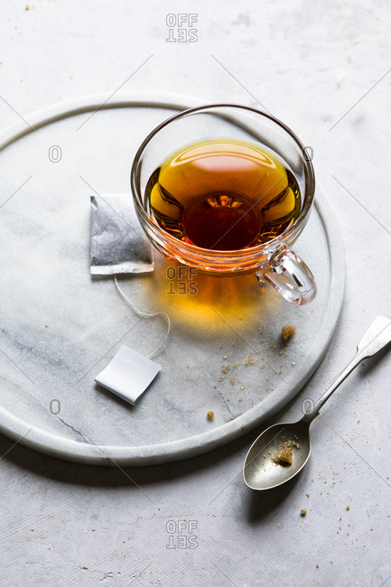 Glass of hot tea with a teabag and sugar cubes