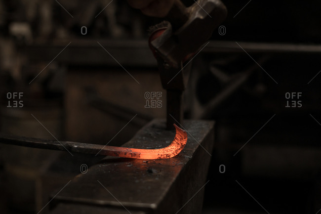 Blacksmith hammering a hot metal rod