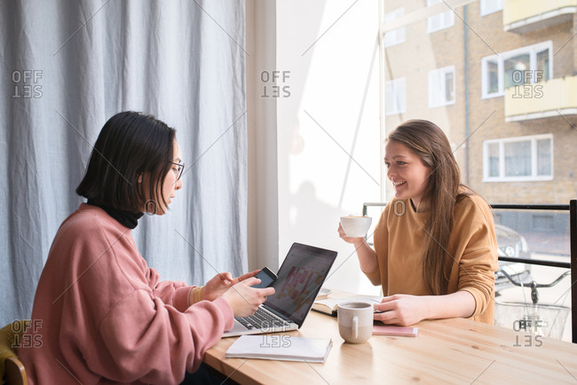 Two women in a coffee shop with a laptop