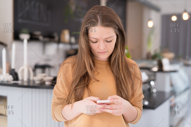 Brunette woman using cell phone in a coffee shop
