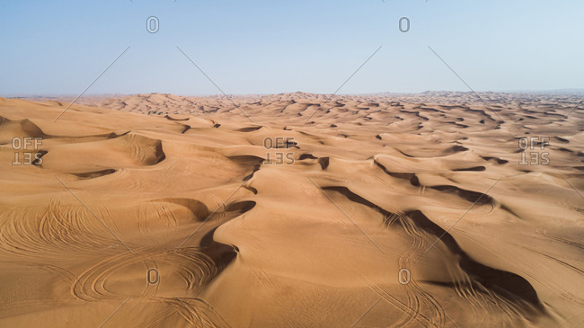 Aerial view of quad bikes tracks in the sandy dunes of Al Bedayer desert in Sharjah, UAE