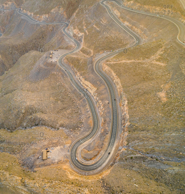 Aerial view of serpentine road in Jebel Jais rocky mountains in Ras Al Khaimah, UAE
