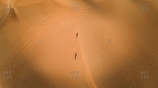 Aerial view of two persons walking in the desert of Sharjah, UAE