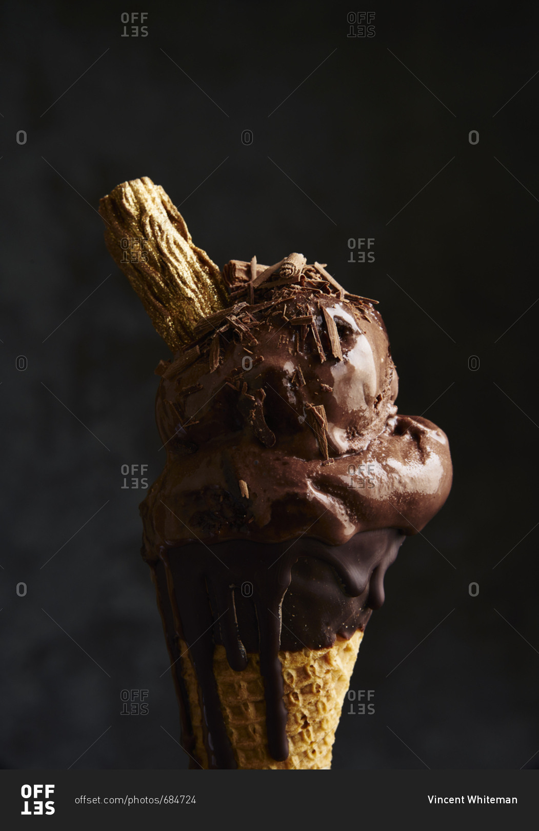 Decadent scoops of chocolate ice cream in cone with flakes of chocolate sprinkled on top