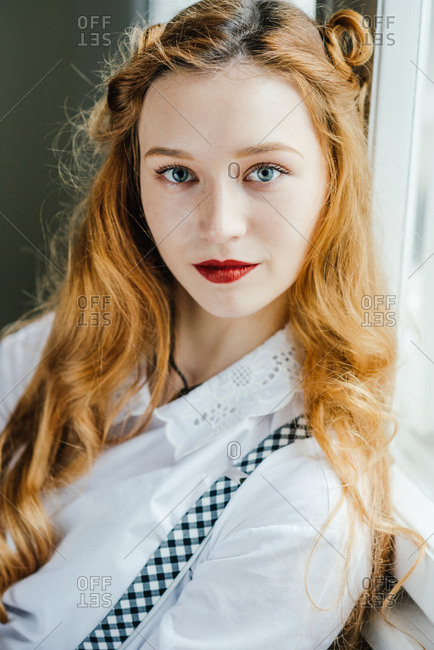 Portrait of beautiful teenager girl with long red hair and blue eyes and pale skin