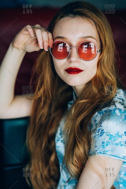Portrait of beautiful red hair girl wearing retro glasses and wearing blue chinese dress