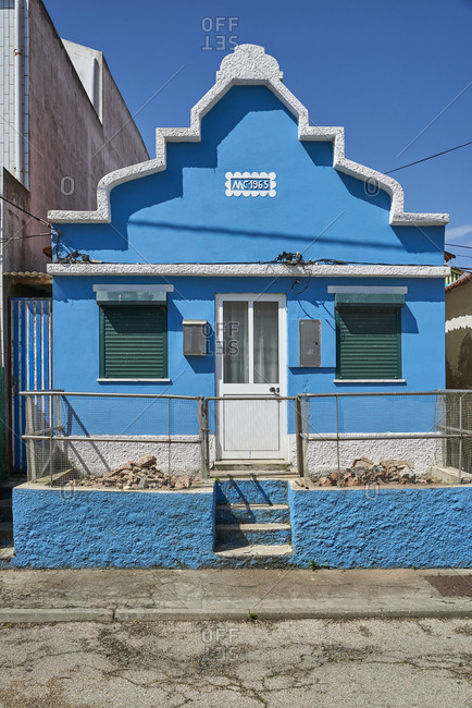 Facade of blue detached house with ornate eaves