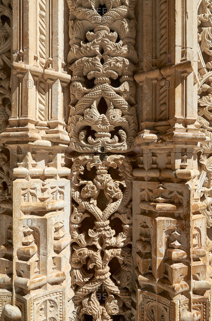 Sunlight highlighting complex carvings in pillar at Batalha Monastery in Portugal