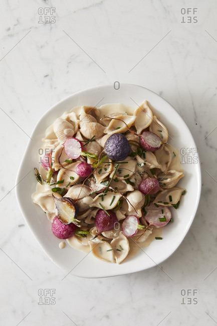 Whole wheat shells with tahini, radishes and chives