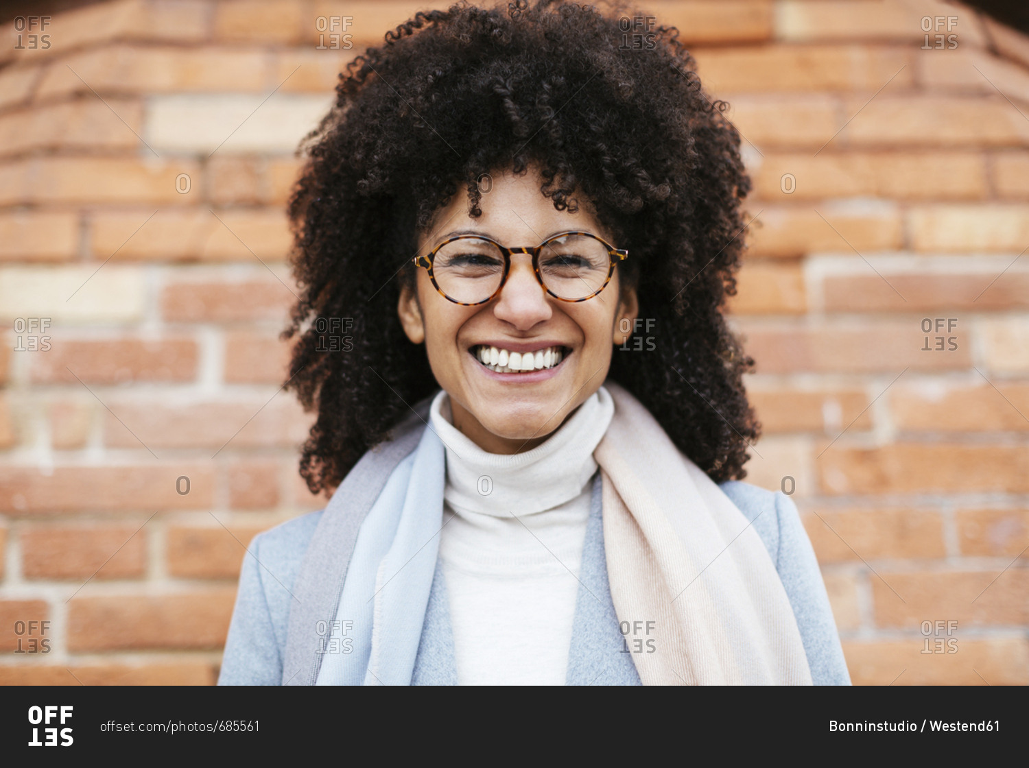 Portrait of happy woman at brick wall