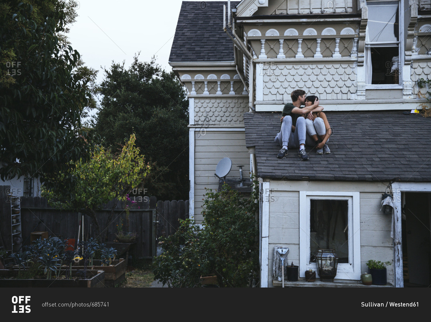 Couple sitting on roof kissing