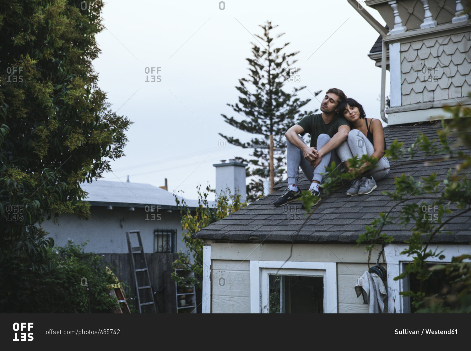 Relaxed couple sitting on roof