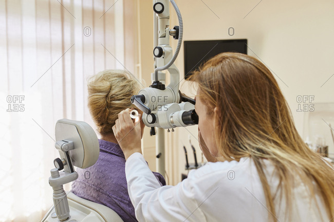 ENT physician examining ear of a senior woman