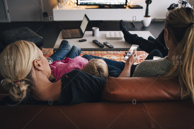 Rear view of family sitting on sofa at home