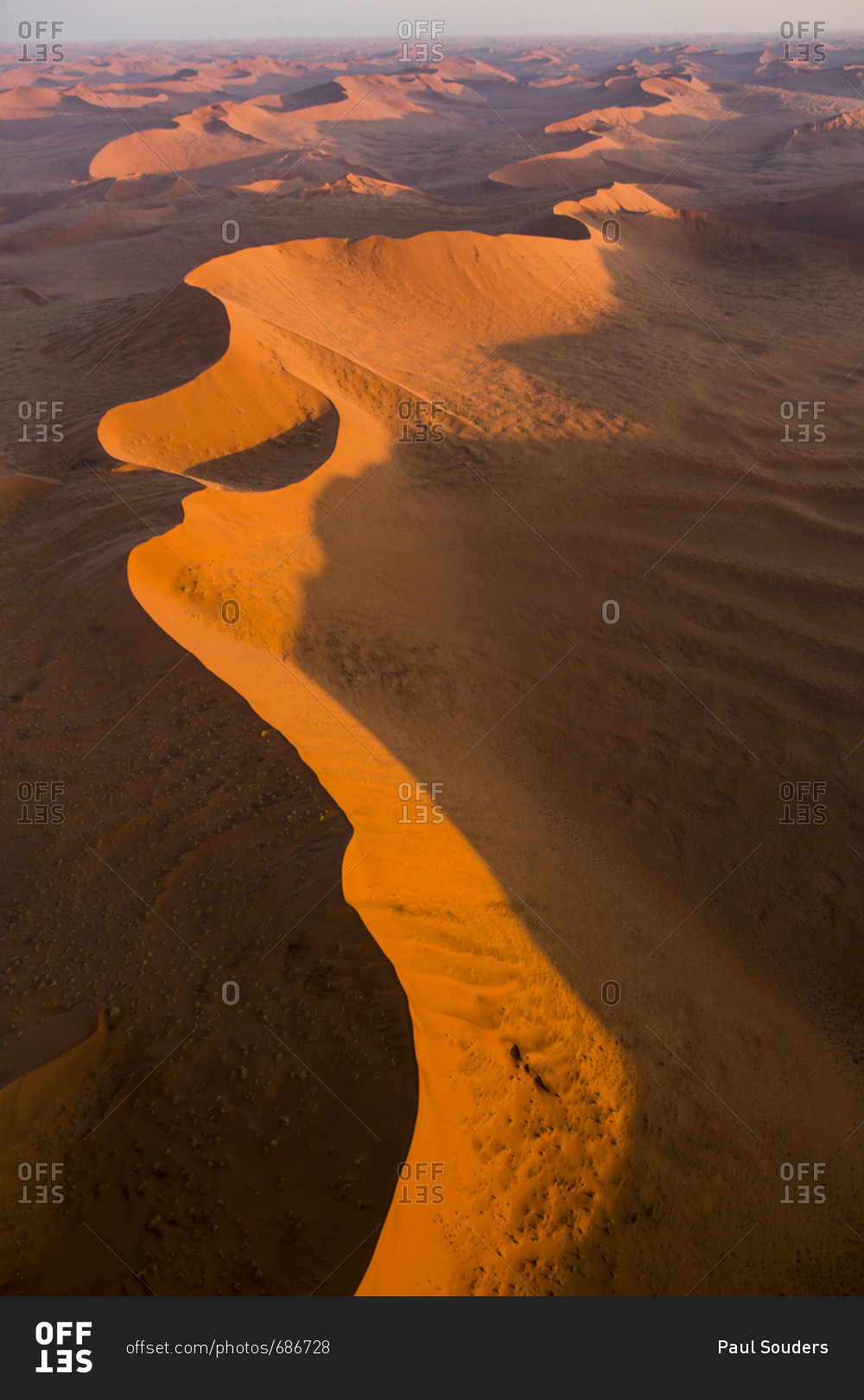 Africa, Namibia, Namib Naukluft National Park, Aerial view of morning sun lighting windblown red
