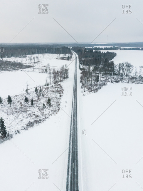 Aerial view of an empty road in the middle of the nordic landscape in winter, Estonia